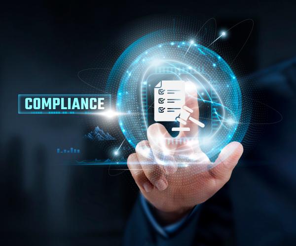 Hand touching digital image of paper and gavel next to the word 'Compliance'