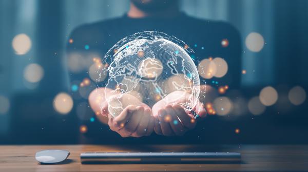 Hands outstretched holding a virtual globe 