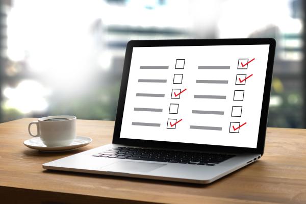 Laptop on desk with ticks in boxes in a form on the computer screen