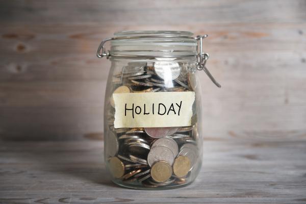 Jar full of coins with label reading Holiday on it