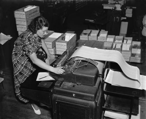 Black and white image of woman operating data processing machine