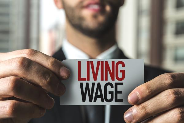 Man holding card up which reads "Living Wage"