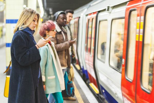 London underground train in a station with travellers waiting to board