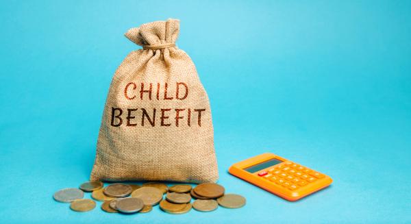 Hessian bag with Child Benefit written on it next to coins and calculator