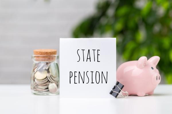 State pension written on card between coin jar and piggy bank