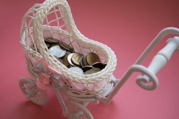 Small toy pram filled with coins
