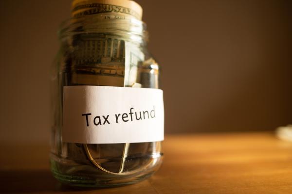 Glass jar containing money, labelled "Tax refund"