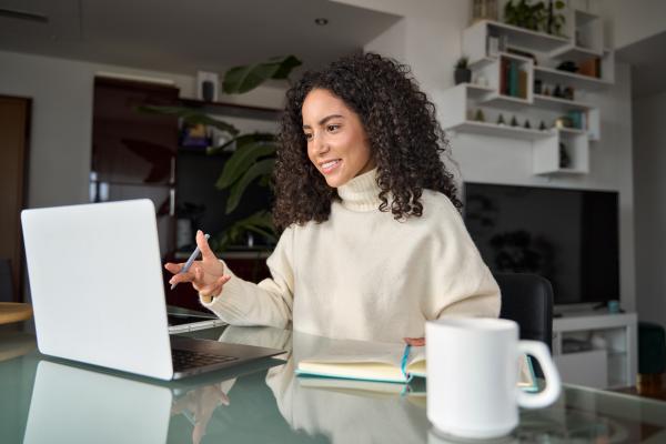 Woman sat at desk at home using a laptop 