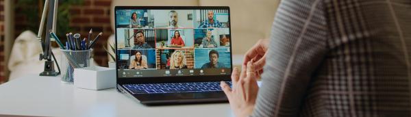 Laptop on desk showing multiple attendees at a webinar